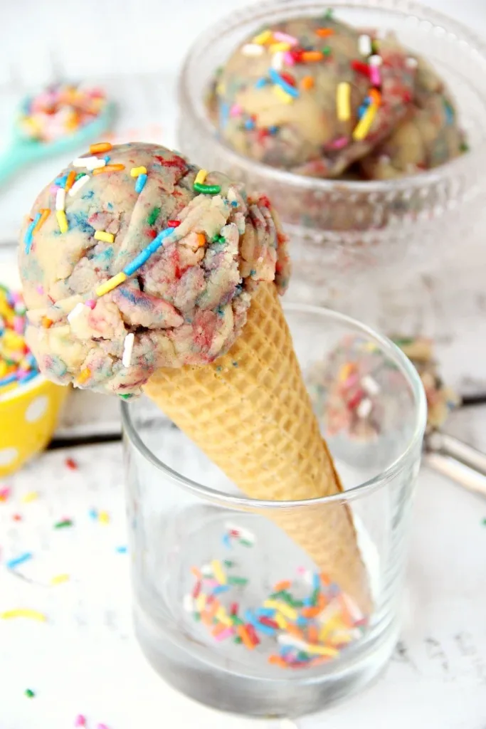 funfetti cookie dough in an ice cream cone with rainbow sprinkles