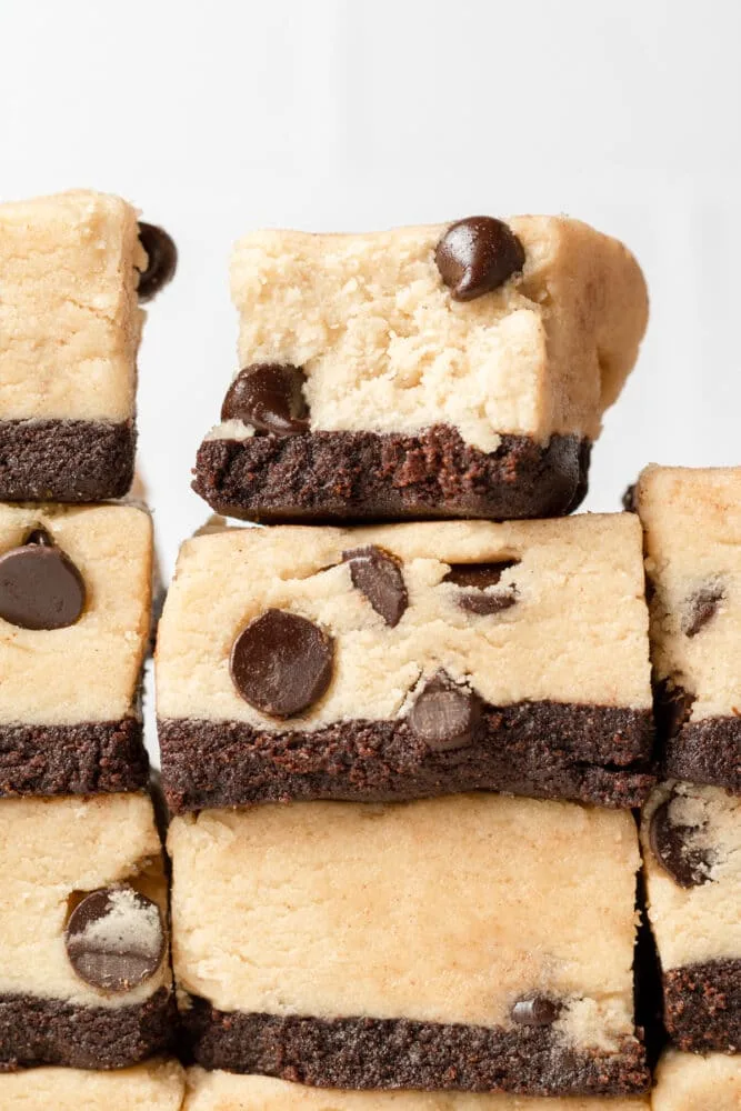 layered dessert bars with a brownie base and thick cookie dough topping, cut into squares
